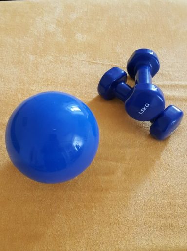 Gymnastikball und Hanteln.